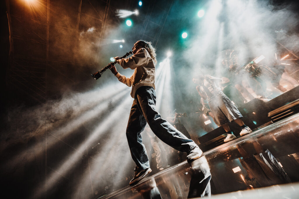Clarinetista a contrapicado entre rayos de luz en el escenario del WOMAD