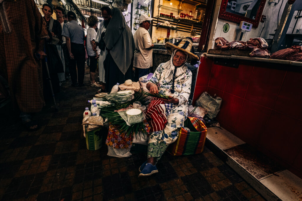 Mujer con sombrero de paja vendiendo hierbas sentada en el mercado de Tánger
