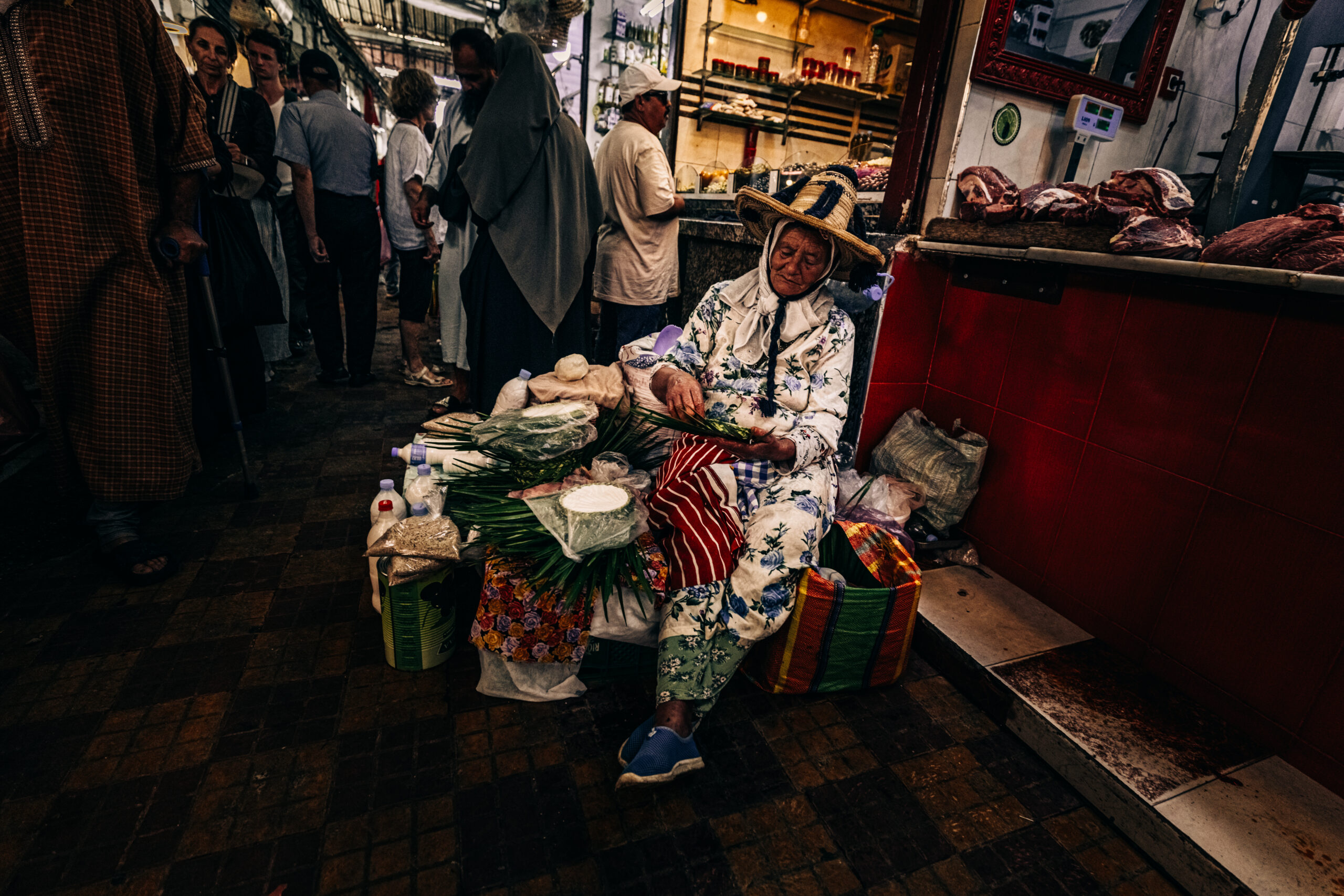 Mujer con sombrero de paja vendiendo hierbas sentada en el mercado de Tánger